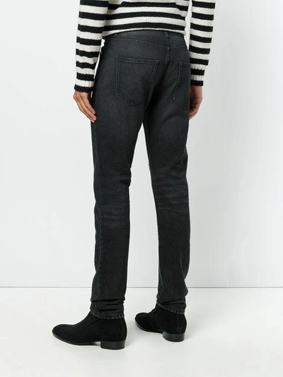 Shop Saint Laurent Vintage Effect Distressed Jeans In Black