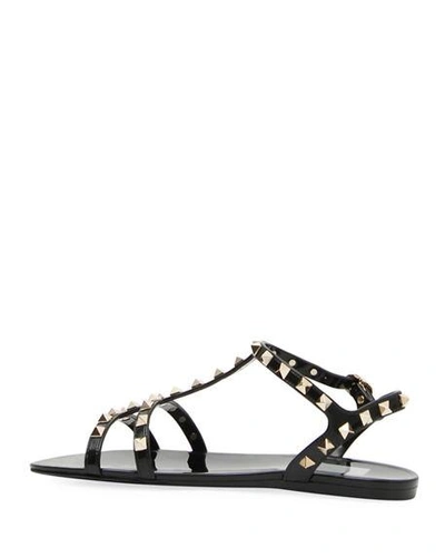 Shop Valentino Rockstud Jelly Flat Gladiator Sandals In Nero