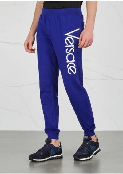 Shop Versace Logo-embroidered Cotton Jogging Trousers In Blue
