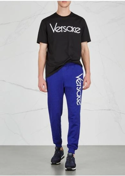 Shop Versace Logo-embroidered Cotton Jogging Trousers In Blue