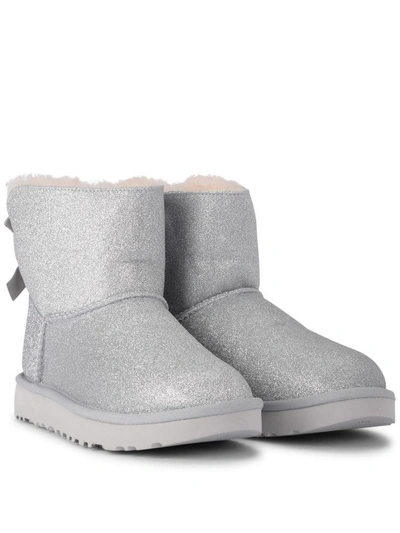 Shop Ugg Mini Bailey Bow Glitter And Silver Sheepskin Ankle Boots In Argento