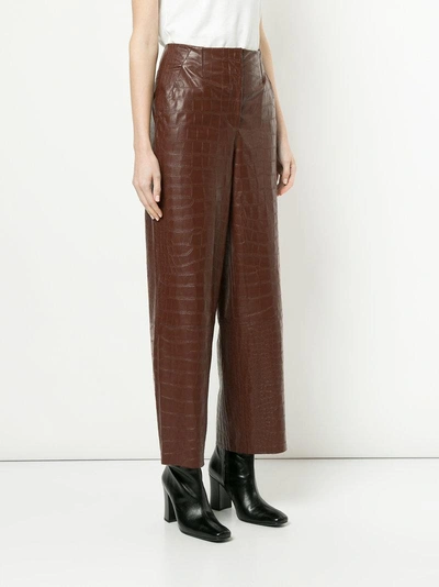 Shop Nanushka Crocodile Embossed Faux Leather Trousers - Brown