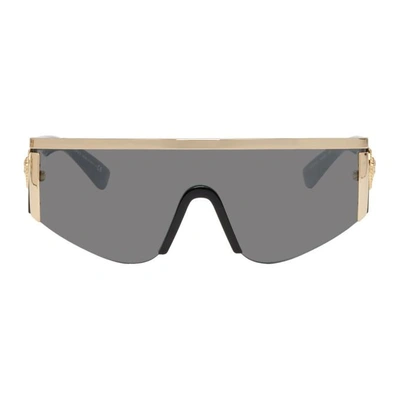 Shop Versace Black And Gold Oversized Metal Shield Sunglasses In 10006g Gold