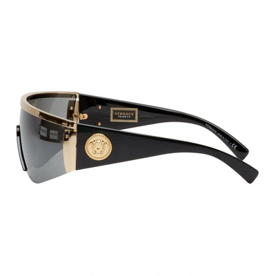 Shop Versace Black And Gold Oversized Metal Shield Sunglasses In 10006g Gold