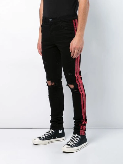 Shop Amiri Distressed Side Stripe Jeans - Black