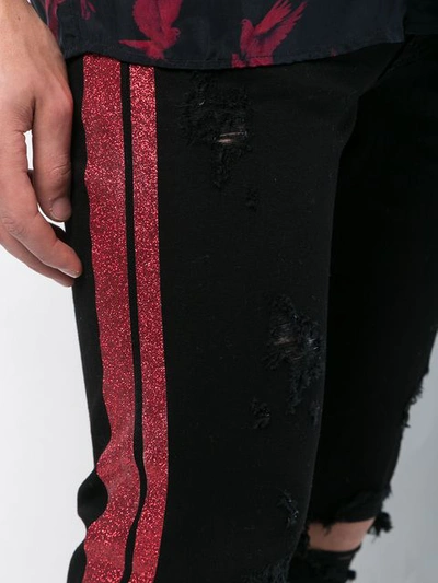 Shop Amiri Distressed Side Stripe Jeans - Black