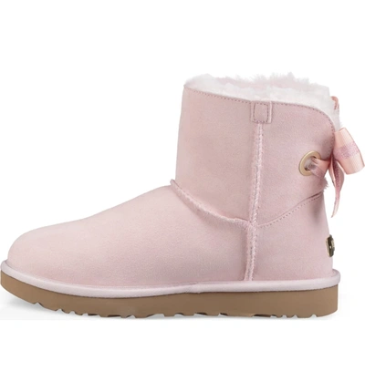 Shop Ugg Customizable Bailey Bow Mini Genuine Shearling Bootie In Seashell Pink Suede