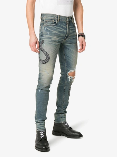 Shop Amiri Snake Embroidered Distressed Jeans In Blue