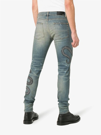 Shop Amiri Snake Embroidered Distressed Jeans In Blue