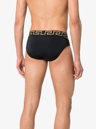 Shop Versace Greek Key Logo Swim Trunks In A80g Black Gold