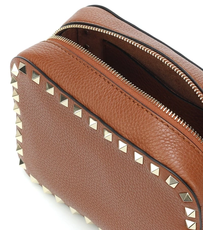 Shop Valentino Garavani Rockstud Leather Crossbody Bag In Brown