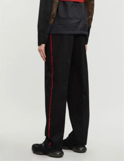 Shop Burberry Text-embroidered Regular-fit Cotton Trousers In Black