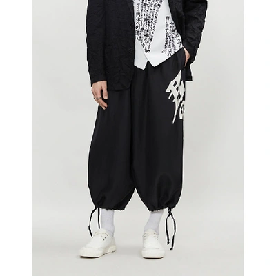 Shop Yohji Yamamoto Graphic-side Cropped Wide-leg Silk Trousers In Black