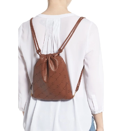 Shop Stella Mccartney Perforated Logo Mini Faux Leather Drawstring Backpack - Brown In Cinnamon