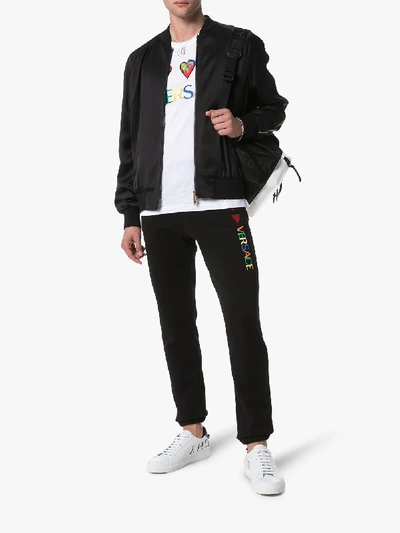 Shop Versace Logo Heart-embroidered Cotton Sweatpants In Black