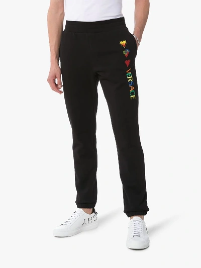 Shop Versace Logo Heart-embroidered Cotton Sweatpants In Black