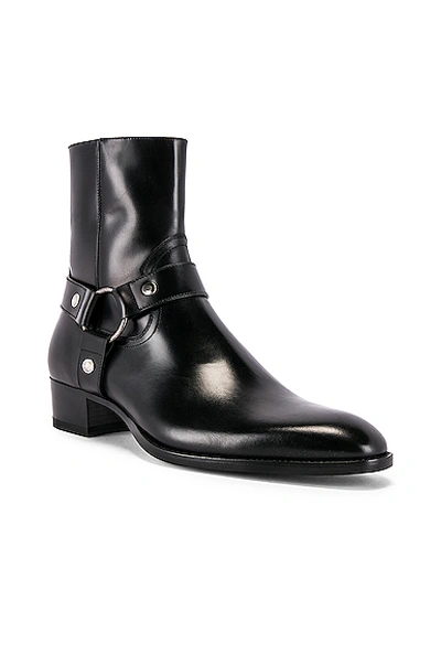 Shop Saint Laurent Wyatt Leather Harness Boots In Black