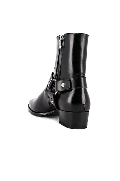 Shop Saint Laurent Wyatt Leather Harness Boots In Black