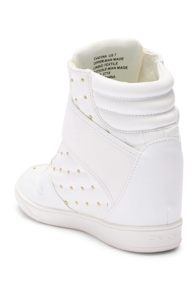 Shop Bebe Studded Hi-top Wedge Sneaker In White Faux