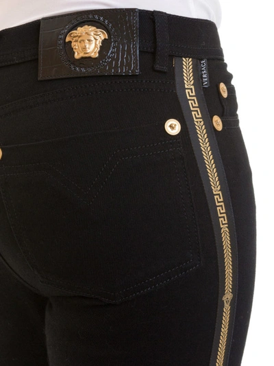 Shop Versace Greek Side Band Slim Fitting Jeans In Black
