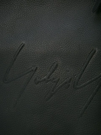 Shop Yohji Yamamoto Embossed Logo Messenger Bag In Black