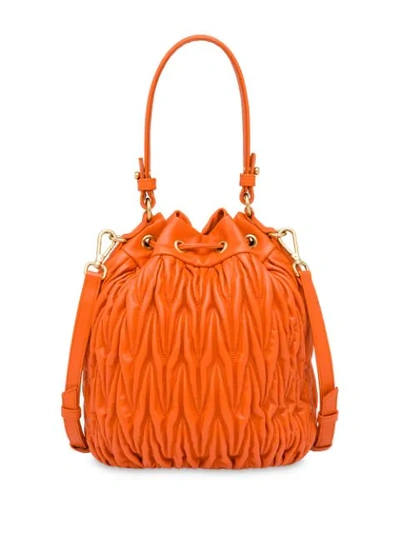 Shop Miu Miu Matelassé Drawstring Bucket Bag In Orange