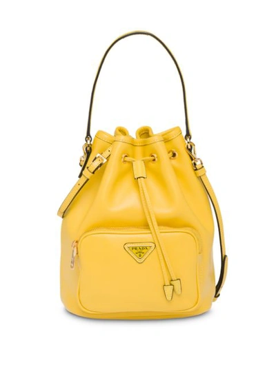Shop Prada Logo Plaque Bucket Bag - Yellow