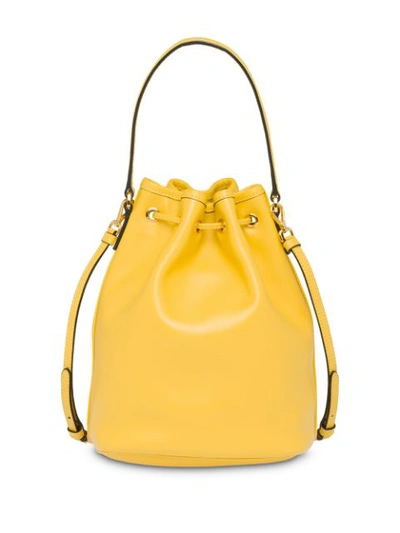 Shop Prada Logo Plaque Bucket Bag - Yellow