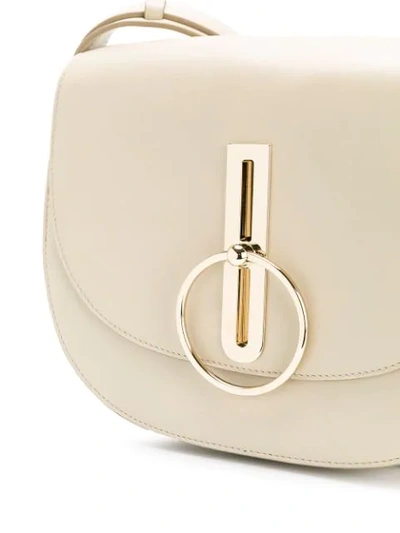 Shop Nina Ricci Disc Buckle Rounded Shoulder Bag In Neutrals