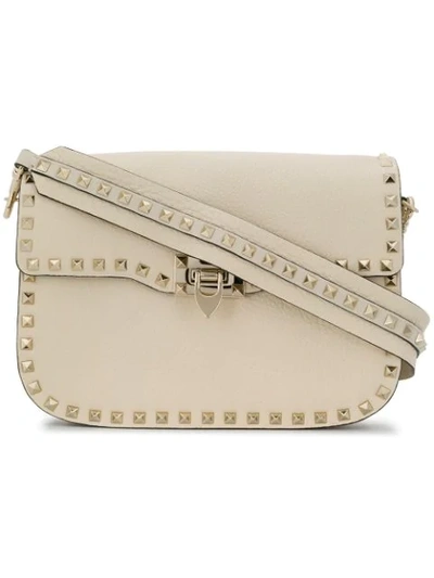 Shop Valentino Garavani Rockstud Rolling Flip-lock Shoulder Bag In Neutrals