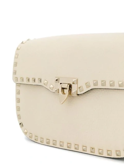 Shop Valentino Garavani Rockstud Rolling Flip-lock Shoulder Bag In Neutrals