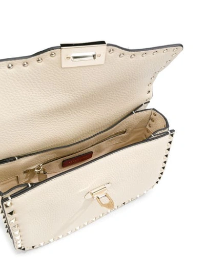 Shop Valentino Garavani Rockstud Rolling Flip-lock Shoulder Bag In Neutrals