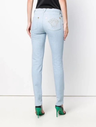 Shop Versace Medusa Stud Skinny Jeans In Blue