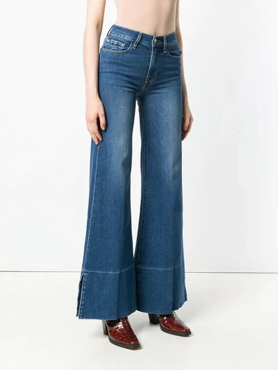Shop Frame Mid Rise Flared Jeans In Blue