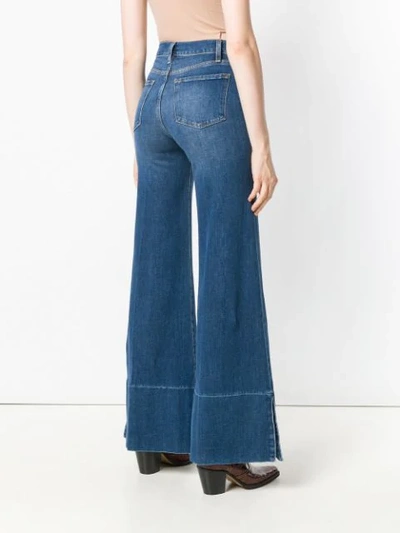 Shop Frame Mid Rise Flared Jeans In Blue