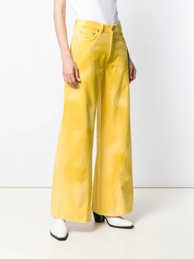 Shop Ganni Flared Denim Jeans In Yellow