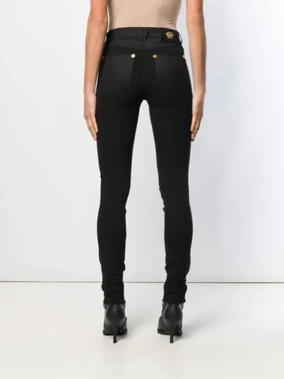 Shop Versace Skinny Trousers In Black