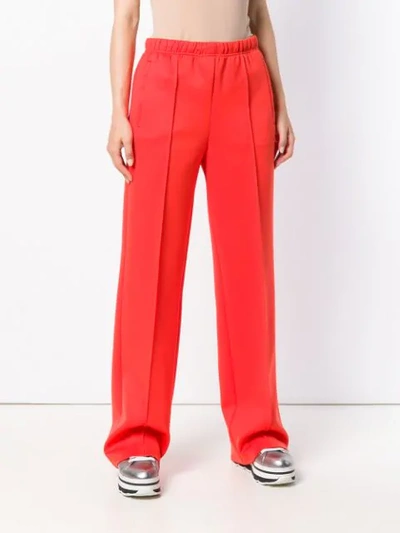 Shop Prada Logo Patch Flared Trousers In Yellow