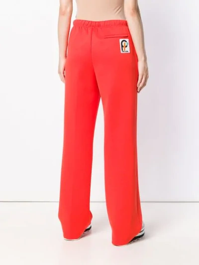 Shop Prada Logo Patch Flared Trousers In Yellow