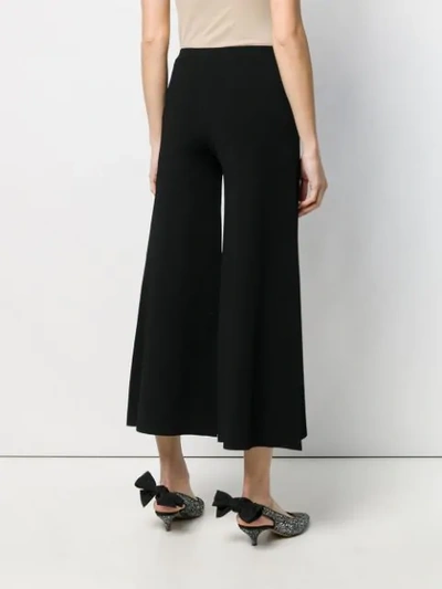 Shop Moschino Cropped Flare Trousers In Black