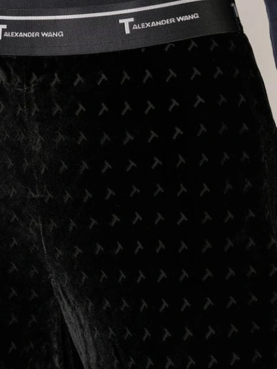 Shop Alexander Wang T Monogram Print Flared Trousers In Black