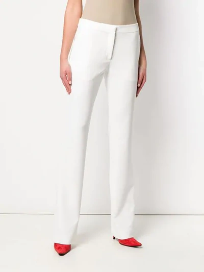 Shop Moschino Bootcut Trousers In White