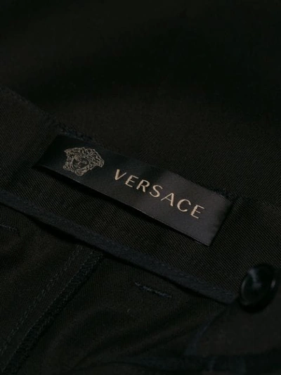 Shop Versace Flared Tailored Trousers In Black
