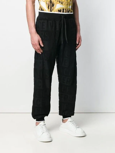 Shop Versace Textured Logo Track Pants In Black