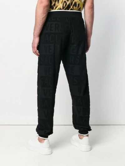 Shop Versace Textured Logo Track Pants In Black