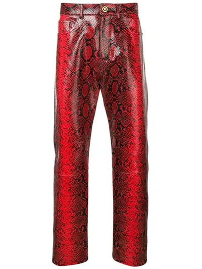 Shop Versace Snake Effect Trousers In Red