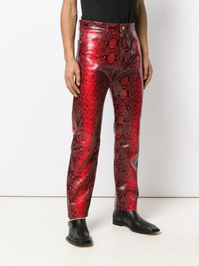 Shop Versace Snake Effect Trousers In Red