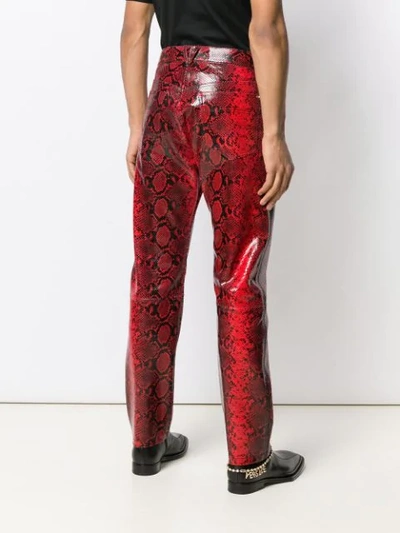 Shop Versace Snake Effect Trousers In Red