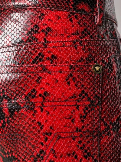 Shop Versace Snake Effect Trousers In Red