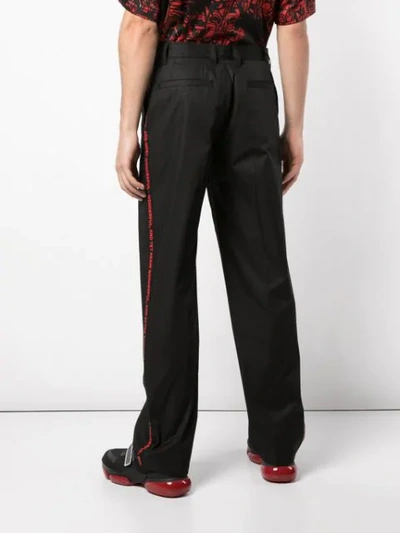 Shop Burberry Contrast Side Print Trousers In Black